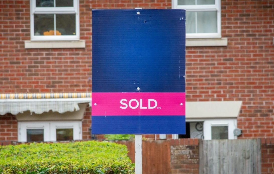 A sold sign in front of a brick building