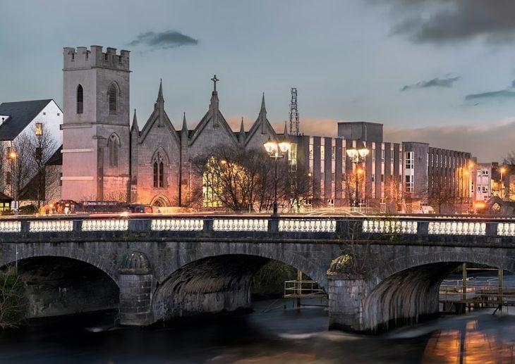 a bridge over a river with a city in the background