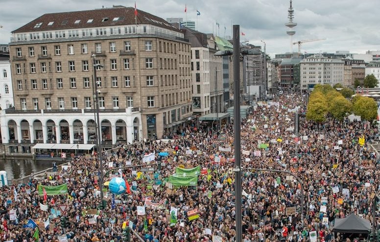 people gathering in event near buildings under white and blue skies during daytime