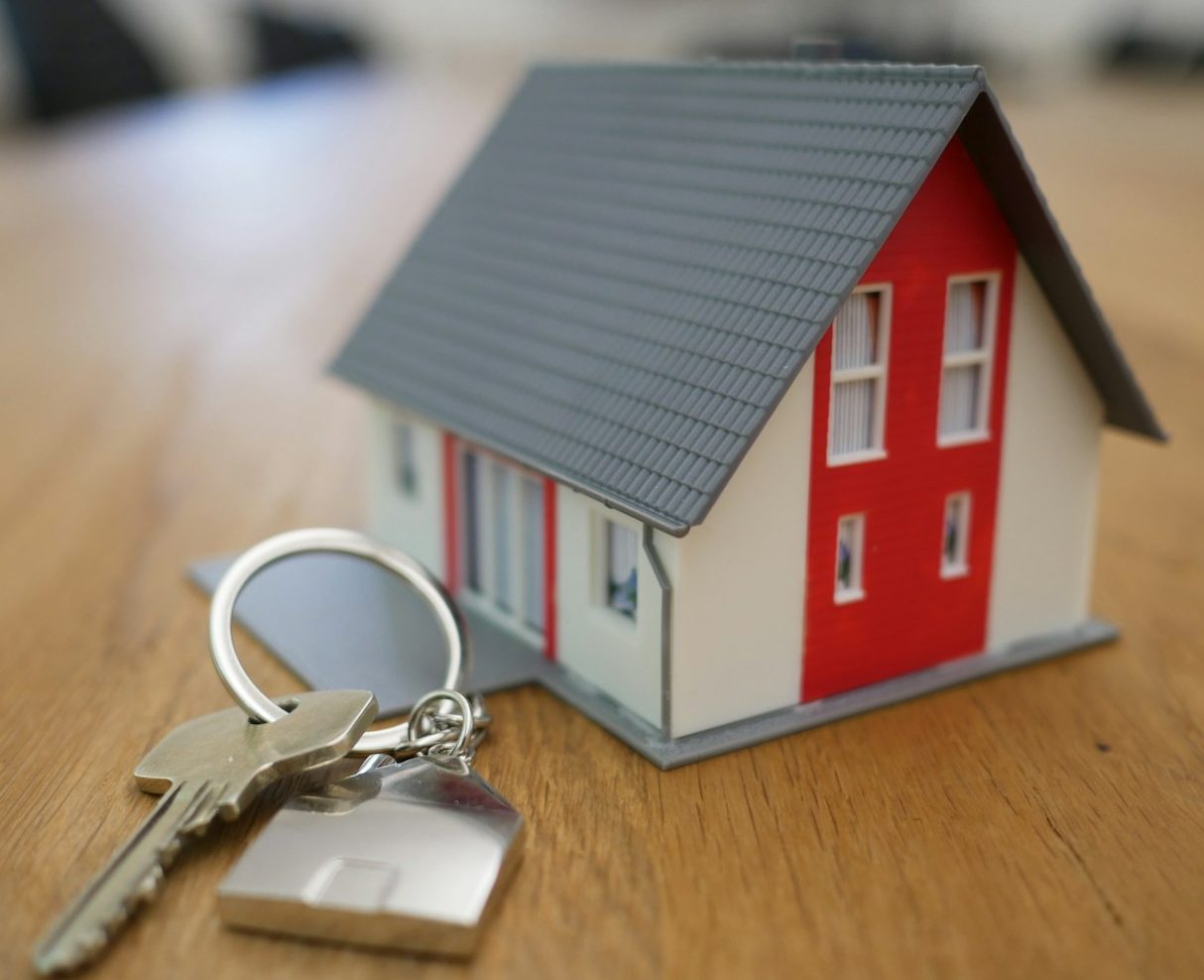 white and red wooden house miniature on brown table
