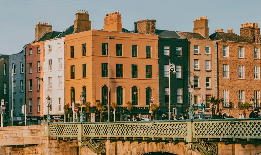 a bridge over a body of water with buildings in the background