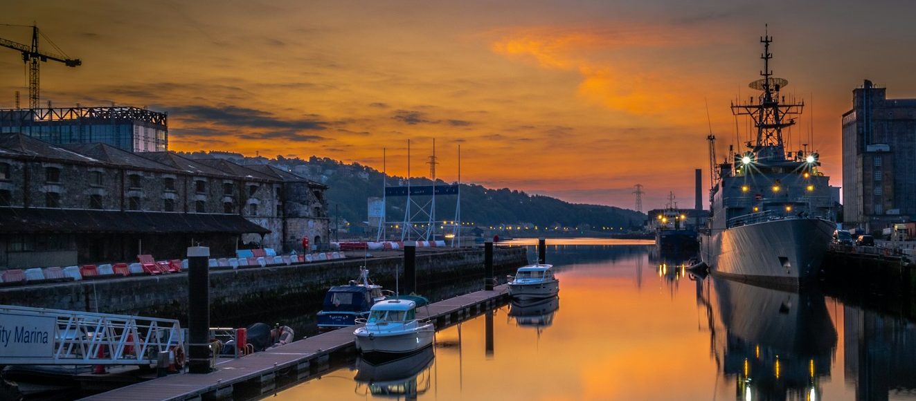 white and black boat on dock during sunset