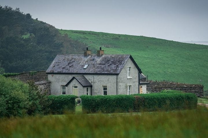 A house sitting on top of a lush green hillside